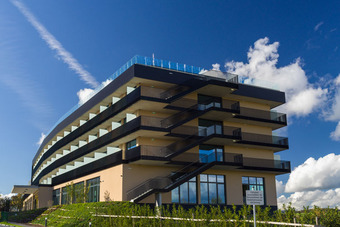 Modernes Gebäude des Best Western Parkhotel Hagenberg mit Glasfassade, Balkonen, markanter Architektur und grüner Umgebung.